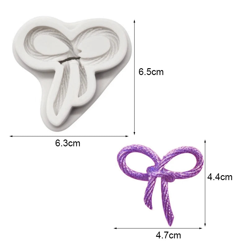 White silicone baking molds shaped like a bow, with dimensions 6.5cm by 6.3cm.
