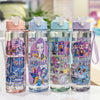 Four clear insulated water cups with colorful cartoon prints and pink lids arranged side by side