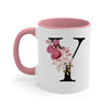 A pink coffee mug with a large black letter Y monogram decorated with pink and white roses.
