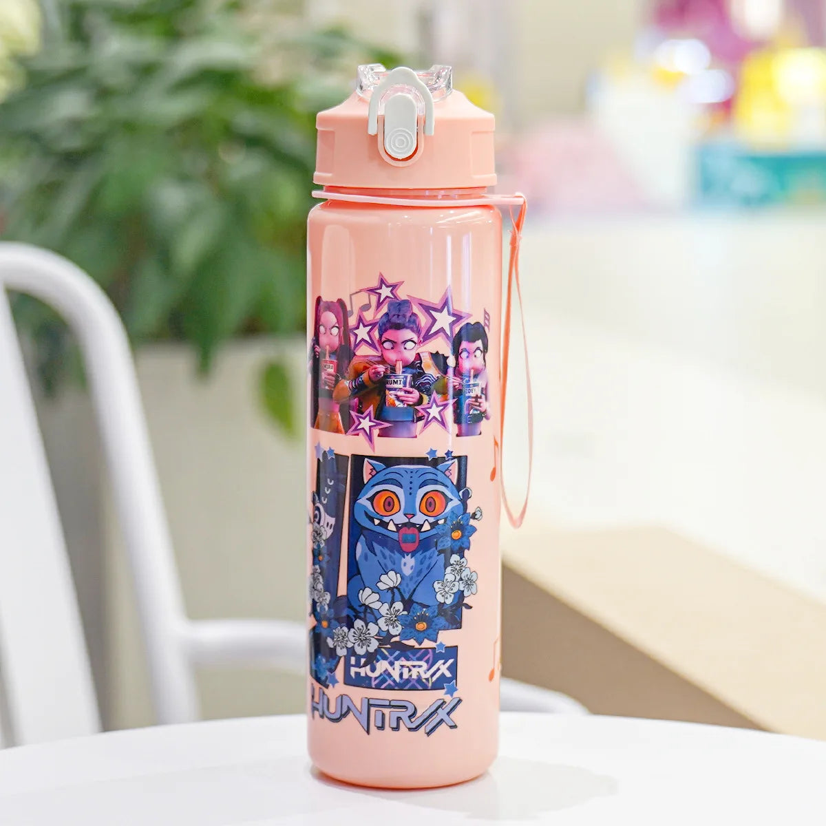 A pink insulated water bottle featuring a cartoon print of characters and an owl.