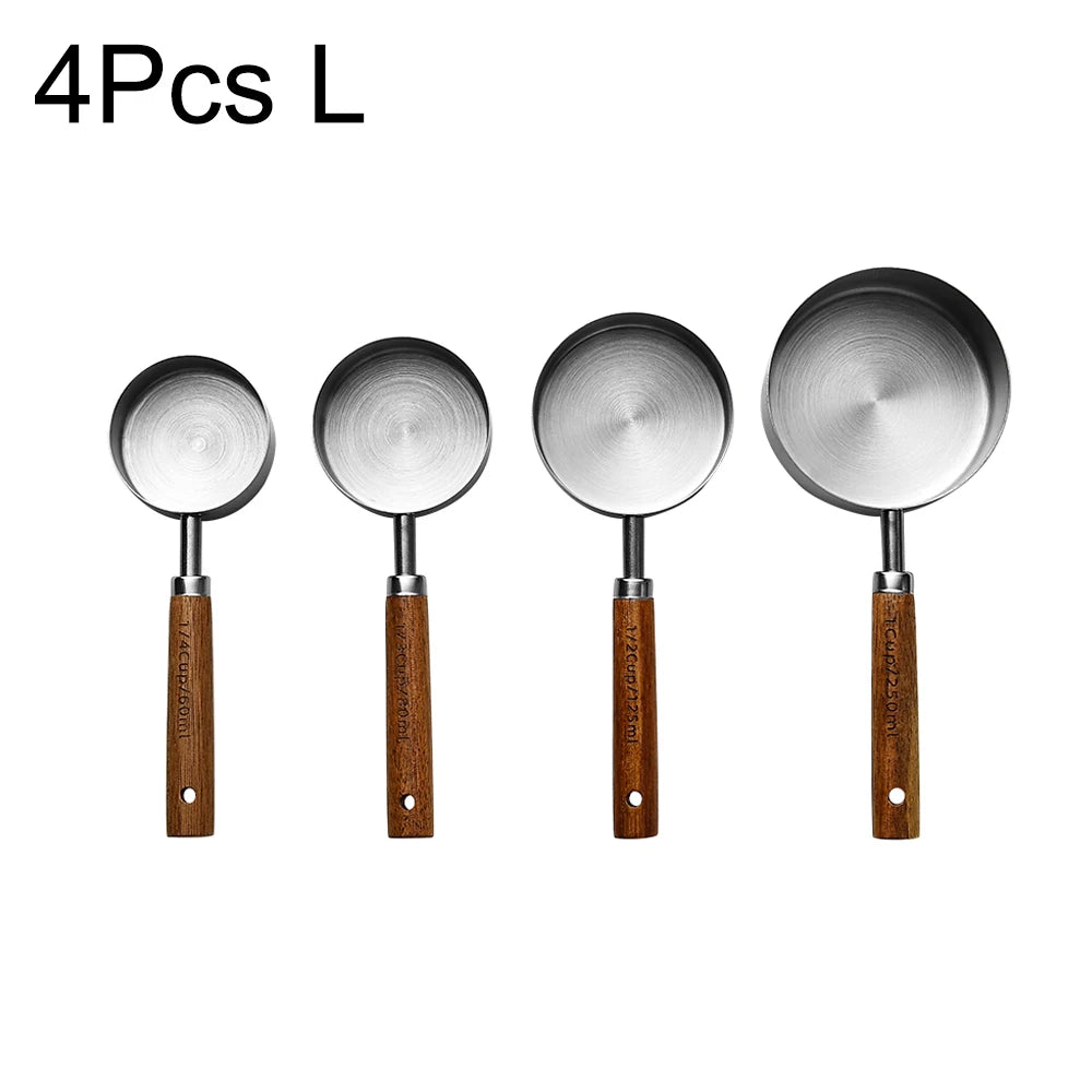 Four stainless steel measuring spoons with wooden handles for baking and bartending