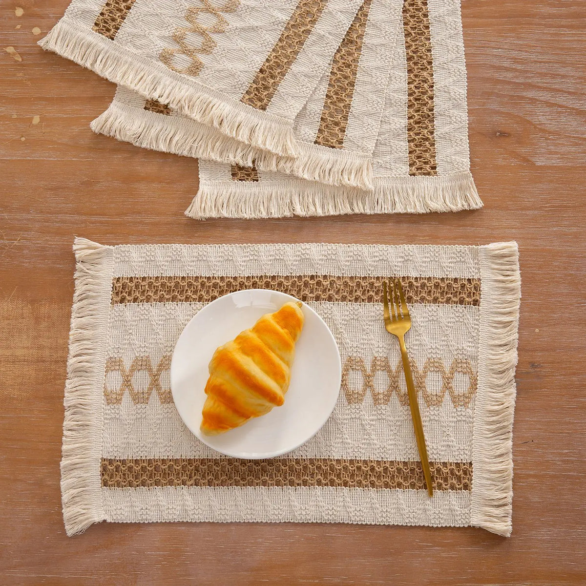 Set aus natürlichen Baumwoll-Burlap-Platzsets mit Fransen, gestreiftes Muster und goldenem Croissant.