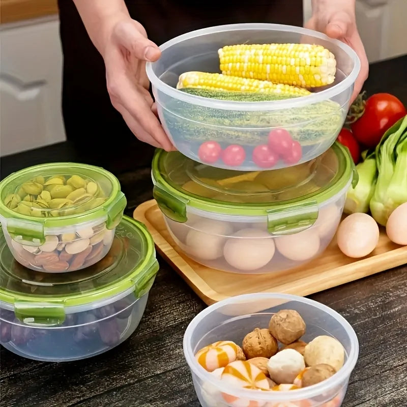 A set of stackable airtight food storage containers, including clear and green plastic containers, filled with corn and eggs.
