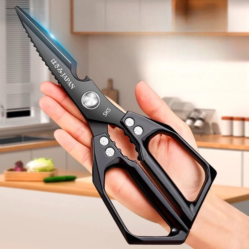 A hand holds a black professional titanium kitchen shear with a silver blade and wooden handle.