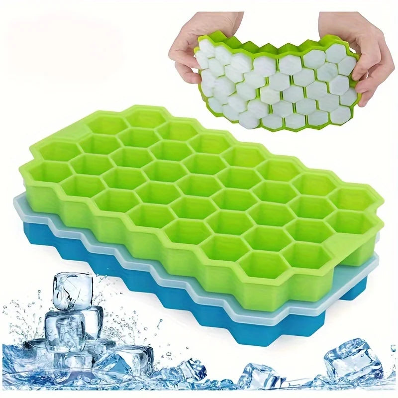 Moldes reutilizables de cubitos de hielo de silicona con tapas en verde y azul, con cubitos de hielo salpicando.
