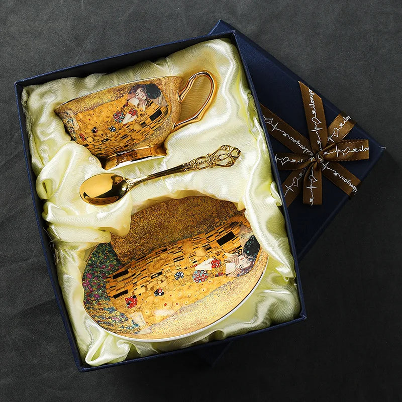 A luxury bone china tea set featuring a golden ceramic cup, spoon, and plate set in a dark blue box with silk lining.