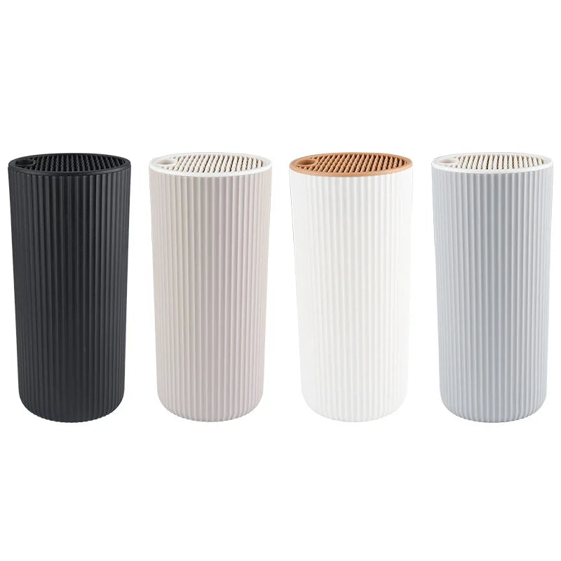 Four cylindrical knife block organizers in black, off-white, and light gray finishes.