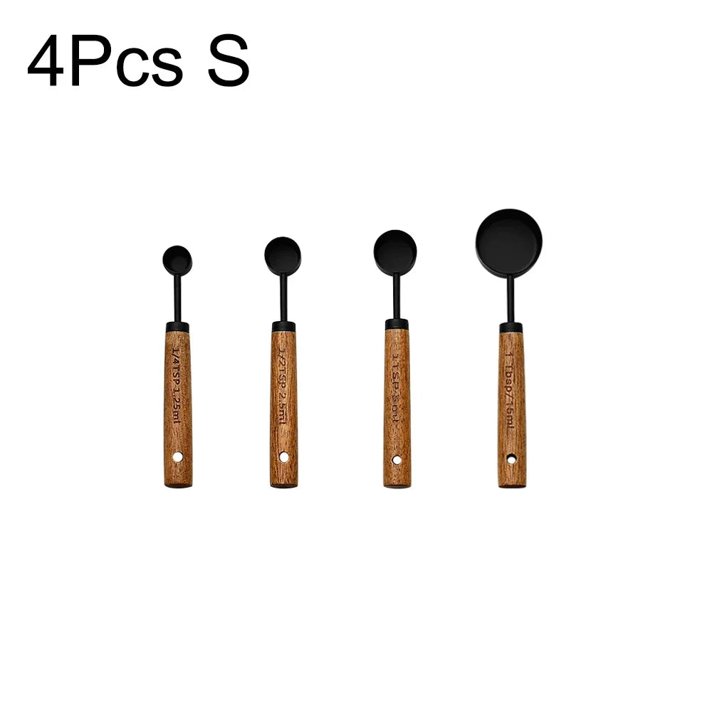 Four stainless steel measuring spoons with wooden handles.