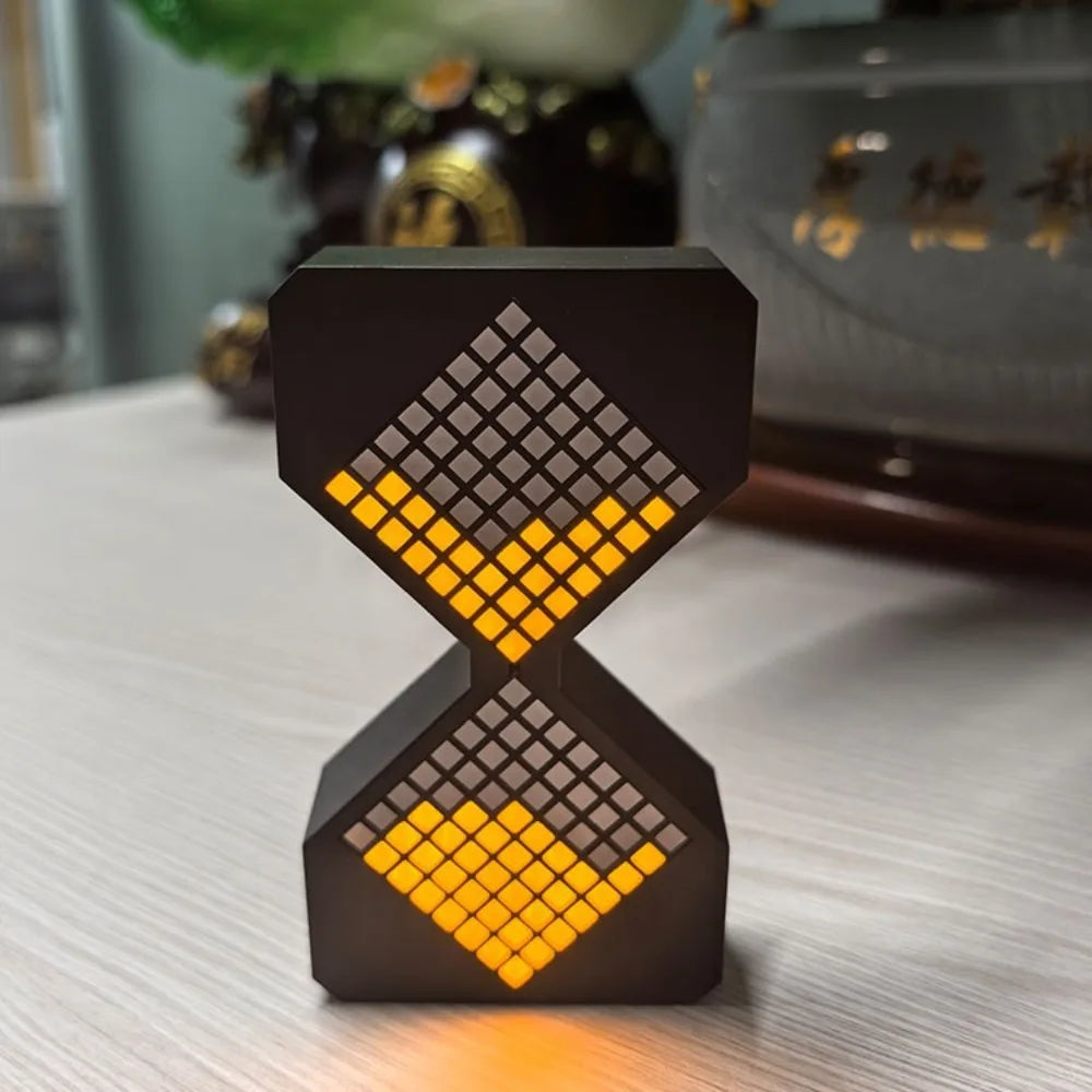 A black digital hourglass timer with an orange LED display, resting on a white surface.