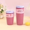 A pink insulated vacuum coffee mug with a white lid is displayed on a light surface.