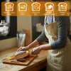 A person uses a wooden bread bow cutter on a cutting board to cut sourdough or homemade bread.