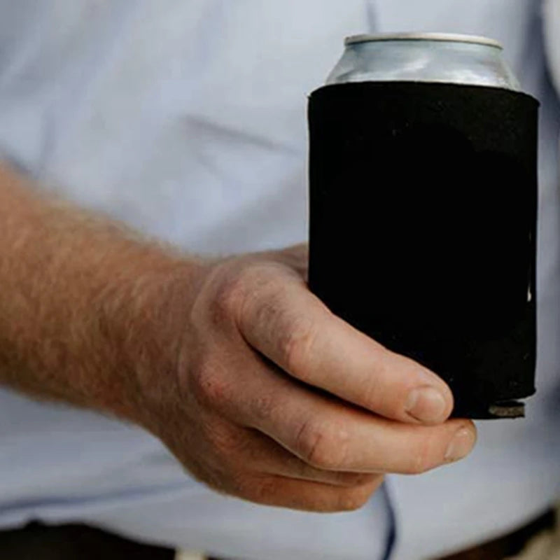 A person is holding a black aluminum beverage can with a silver top.