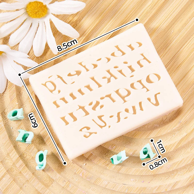 A silicone alphabet cake decoration mold with various letters and numbers shown on a wooden surface.