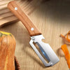 A stainless steel vegetable peeler with a wooden handle is shown next to a squash.