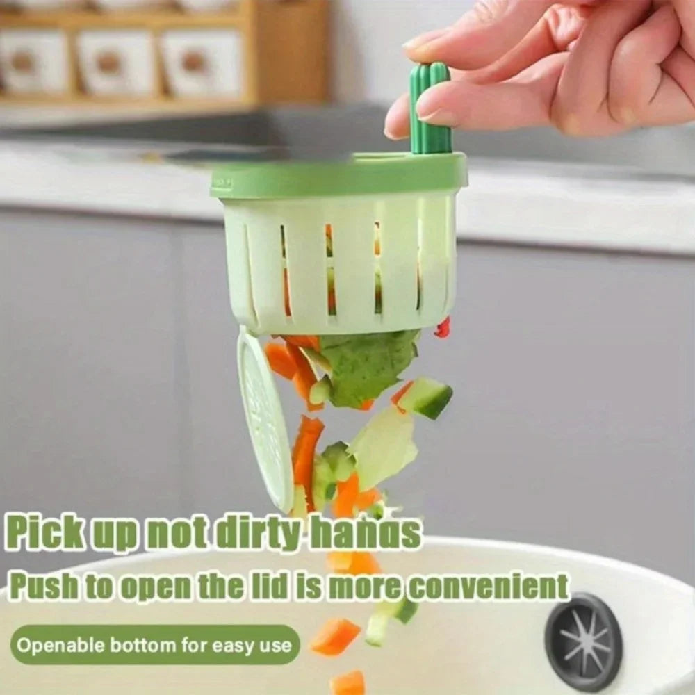 A hand is using an automatic cactus sink drain strainer to pick up food scraps from a sink.