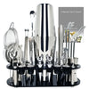 Professionelles Cocktail-Shaker-Set mit verschiedenen Edelstahlwerkzeugen und Gadgets auf einem schwarzen Tablett.