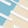 A collection of individually wrapped clear plastic drinking straws displayed on a light background.