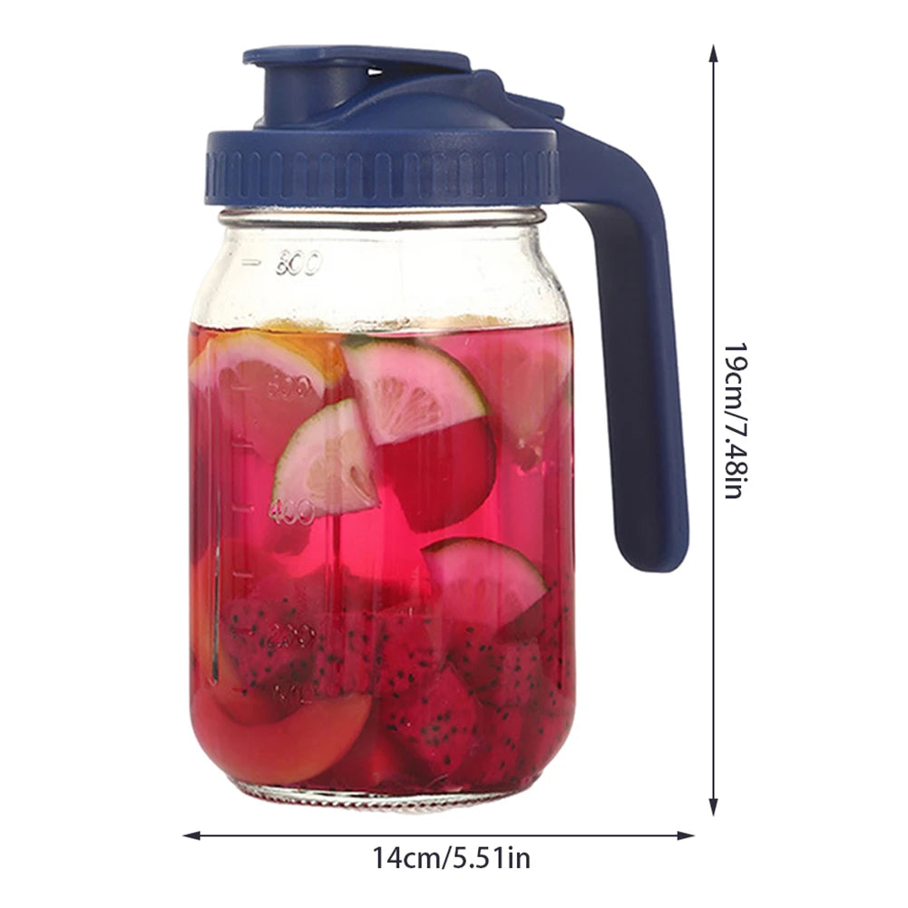 Jarra de vidrio con un verser azul, llena de jugo de fruta rosa y rojo.