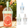 A clear reusable tumbler coffee cup with a green lid and straw, shown in various views.