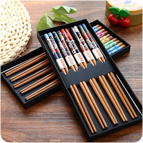 A set of natural bamboo chopsticks with non-slip grips arranged in a black wooden box.