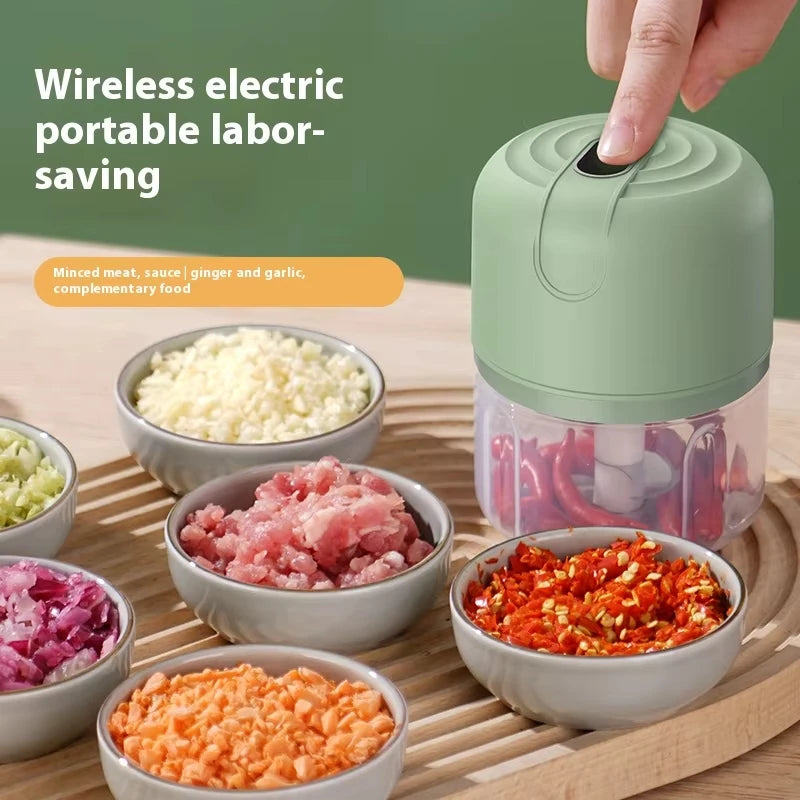 A hand is shown squeezing a green electric portable labor-saving food grinder mixer with various ground spices and ingredient