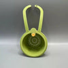 A light green press-type drain basket with a handle is shown against a gray background.