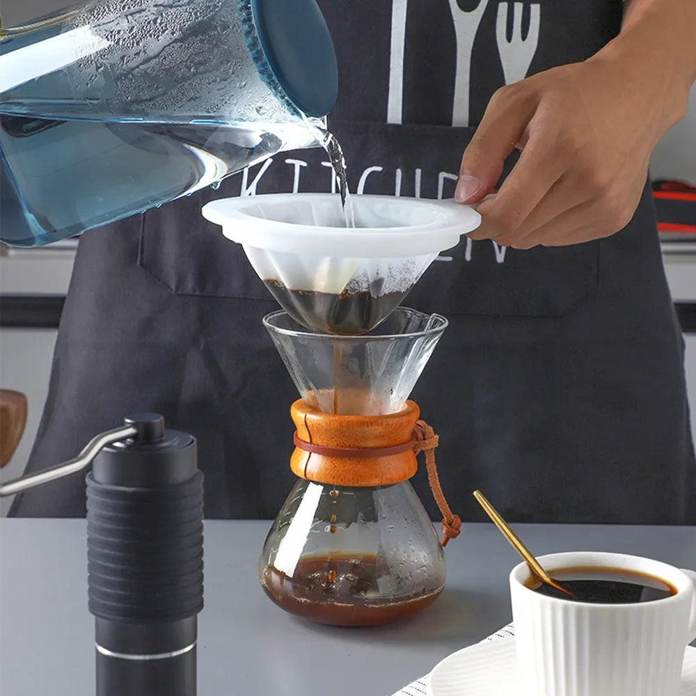 A hand pours liquid into a multi-mesh fine strainer placed over a glass, demonstrating beverage preparation.