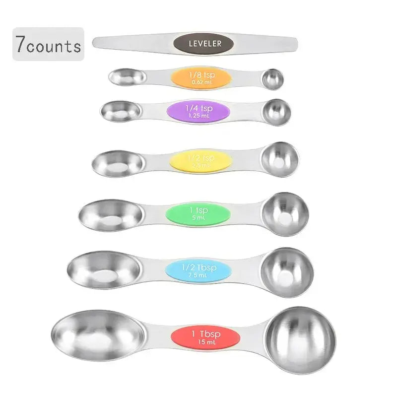 A set of seven magnetic stainless steel measuring spoons with various sizes and markings.