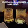 A close-up of a glowing crystal coaster with an LED light illuminating the glass.