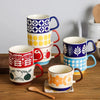 Un set de tasses à café en céramique japonaises rétro colorées avec des motifs floraux et géométriques en rouge, jaune, bleu 