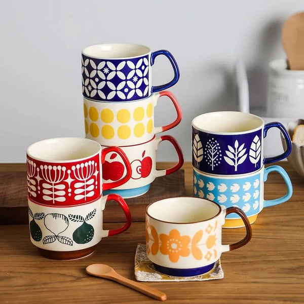 Set bunter retro japanischer Keramiktassen mit floralen und geometrischen Mustern in rot, gelb, blau und weiß.