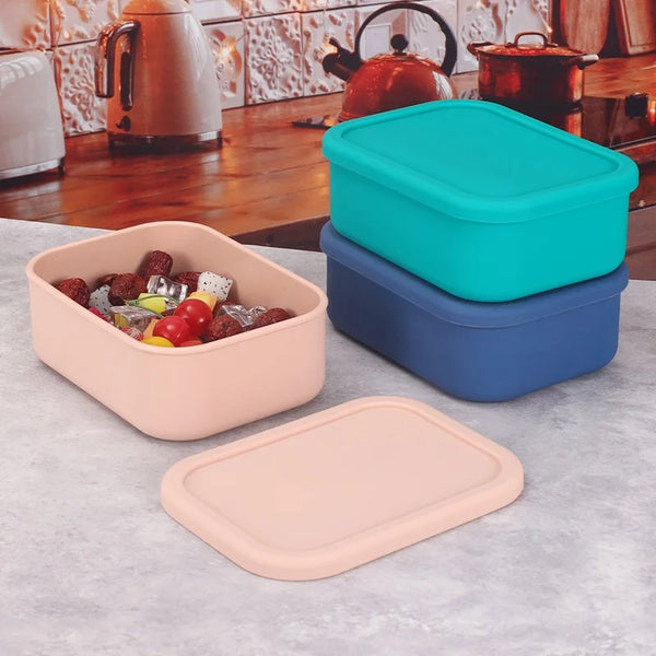 Ein Set aus dichten Silikon-Bento-Boxen in Türkis und Blau mit einem rosa Tablett, auf einer Arbeitsplatte präsentiert.