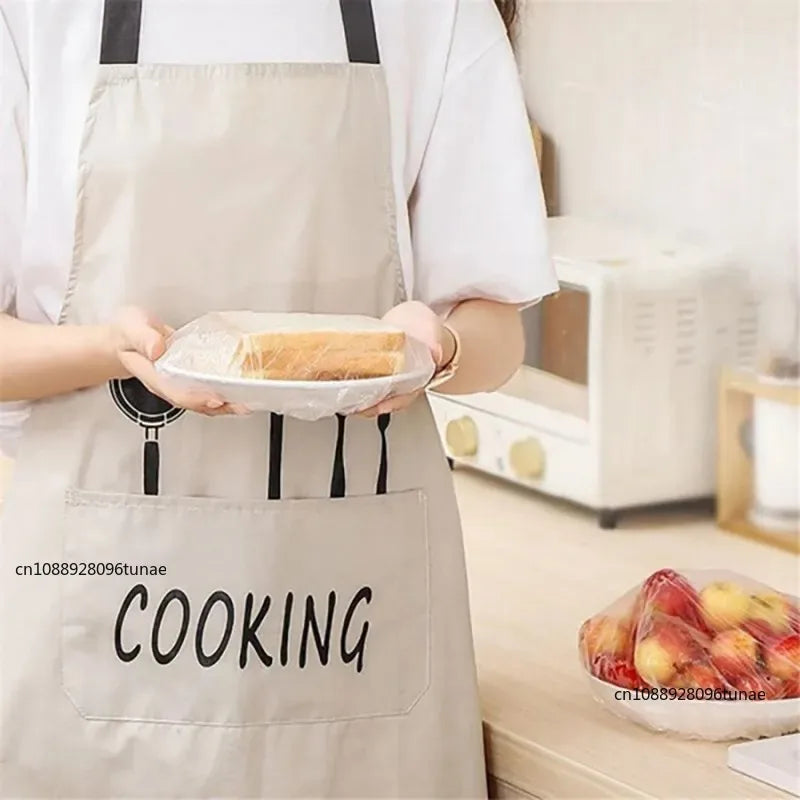 A person wearing an apron is holding a white plate with baked goods, demonstrating reusable food storage bags.