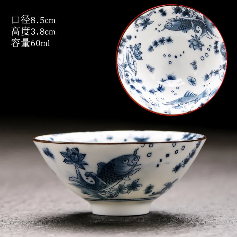 A white porcelain bowl with blue floral and fish patterns is shown against a dark background.