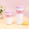 A white vacuum insulated coffee mug with a pink lid and a yellow silicone coaster.