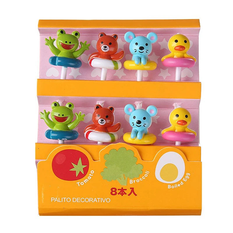 A box of cute fruit and dessert picks for kids featuring green, orange, blue, and yellow characters on a pink and orange back