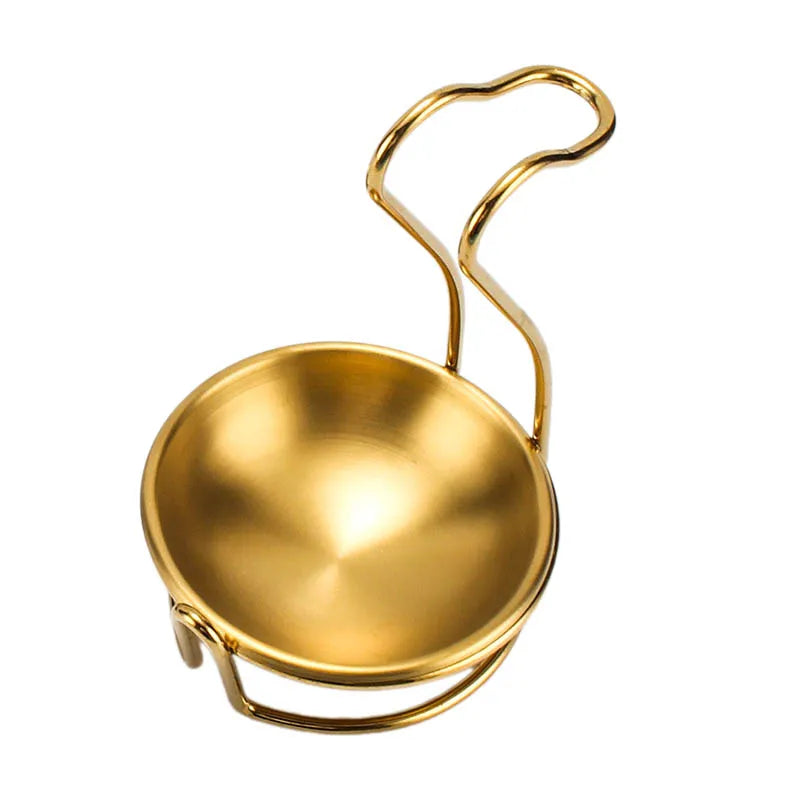 A golden stainless steel hot pot colander with a wire handle.