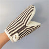 A close-up of a hand wearing striped beige and black insulated kitchen baking gloves.