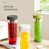 Three glass jars of cold water juice or drink sitting on a wooden table.