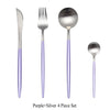 A set of four purple and silver stainless steel cutlery including a fork, spoon, knife, and serving utensil.