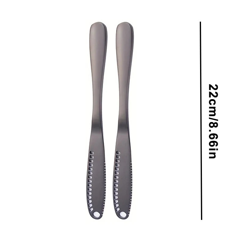 A pair of sleek, dark gray stainless steel butter knives with a modern design.