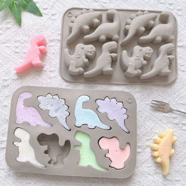 A silicone mold tray containing various colored dinosaur shapes for making chocolate or candy.