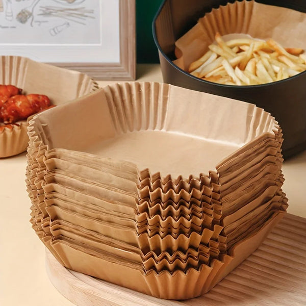 Eine Stapel brauner Antihaft-Backformen neben einer dunklen Pfanne mit Pommes frites.