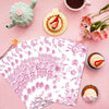 مجموعة من مناديل طعام زهرية يمكن التخلص منها بألوان وردي وأخضر، مرتبة على سطح وردي.