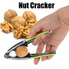 A hand holds a stainless steel nut cracker, demonstrating its use for cracking nuts like walnuts and pecans.