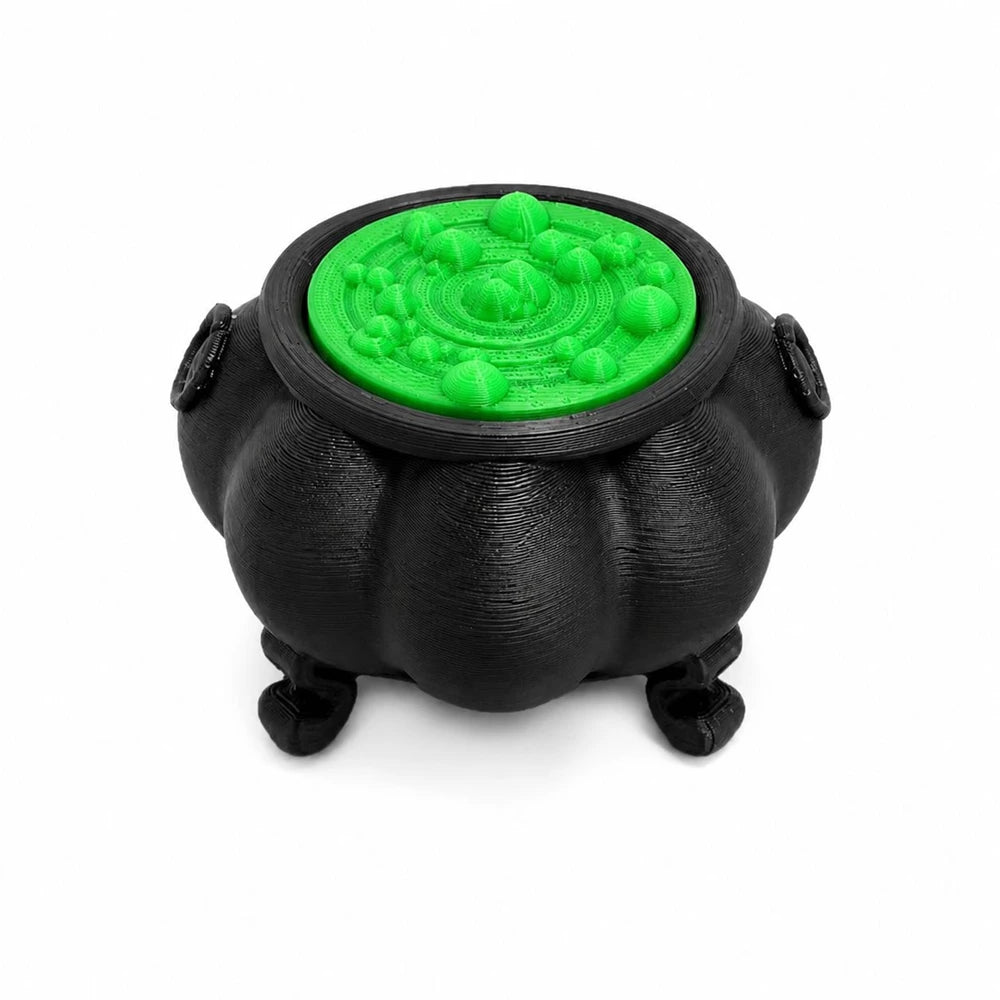 A black cauldron ornament with a bright green, textured lid.