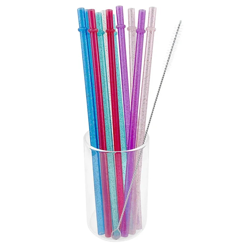 A collection of colorful glitter reusable plastic straws with cleaning brushes in a clear container.