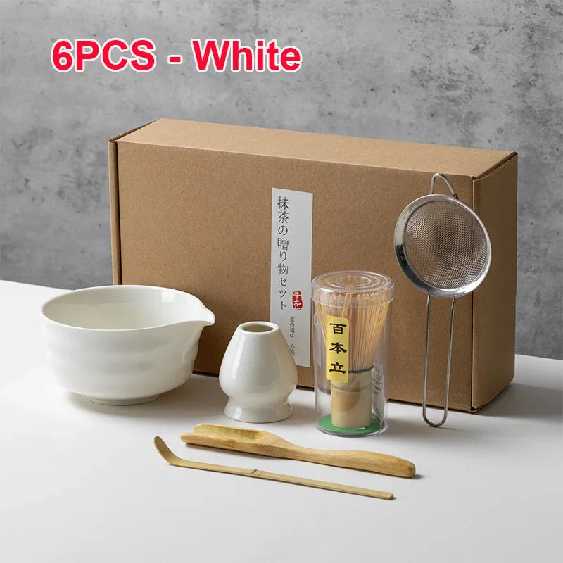 Un juego de seis herramientas para té matcha blancas, incluyendo un cuenco, batidor y colador, empaquetado en una caja de car