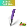 A purple fruit parer knife with a black blade is shown next to fresh vegetables.