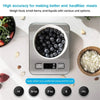 A portable digital kitchen scale is shown measuring blueberries in a white bowl on a light surface.